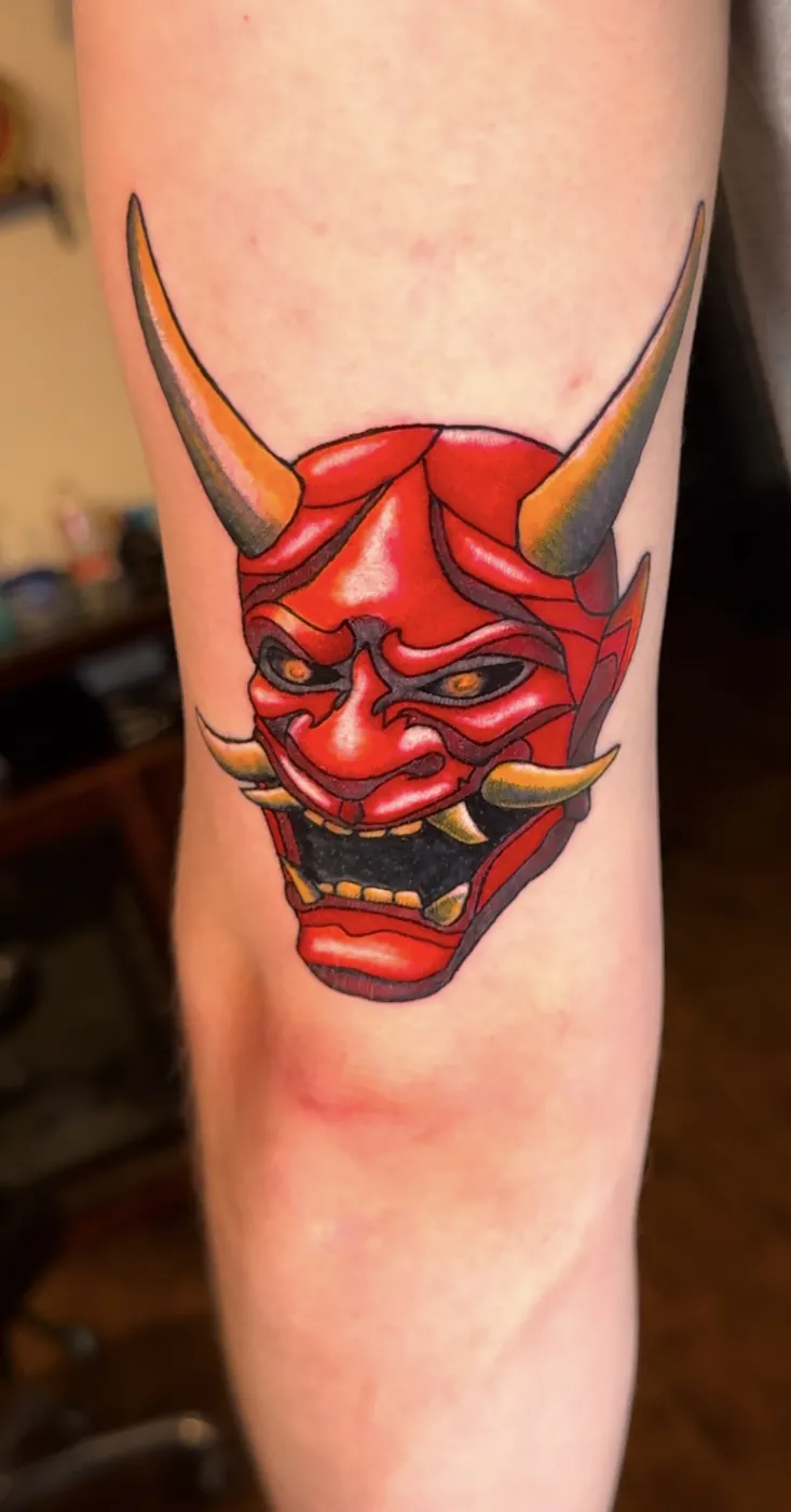 Masque hannya rouge, tatoué sur le bras, couleur pleine.