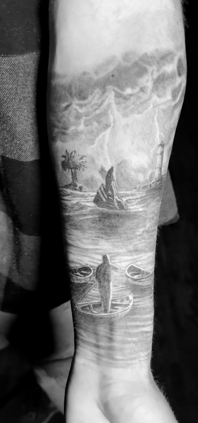 Scène marine d'orage, phare et chaloupes échouées, tatouée sur l'avant-bras.